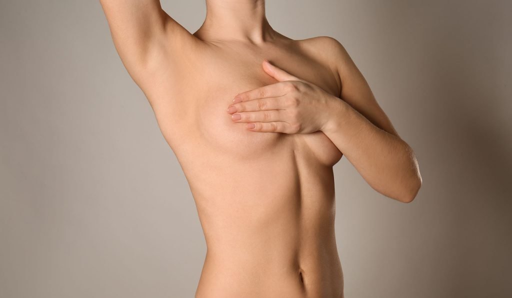 Naked woman on grey background. Concept of breast augmentationReconstruction du sein - Chirugie esthétique et plastique à Paris et Boulogne - Dr Staub